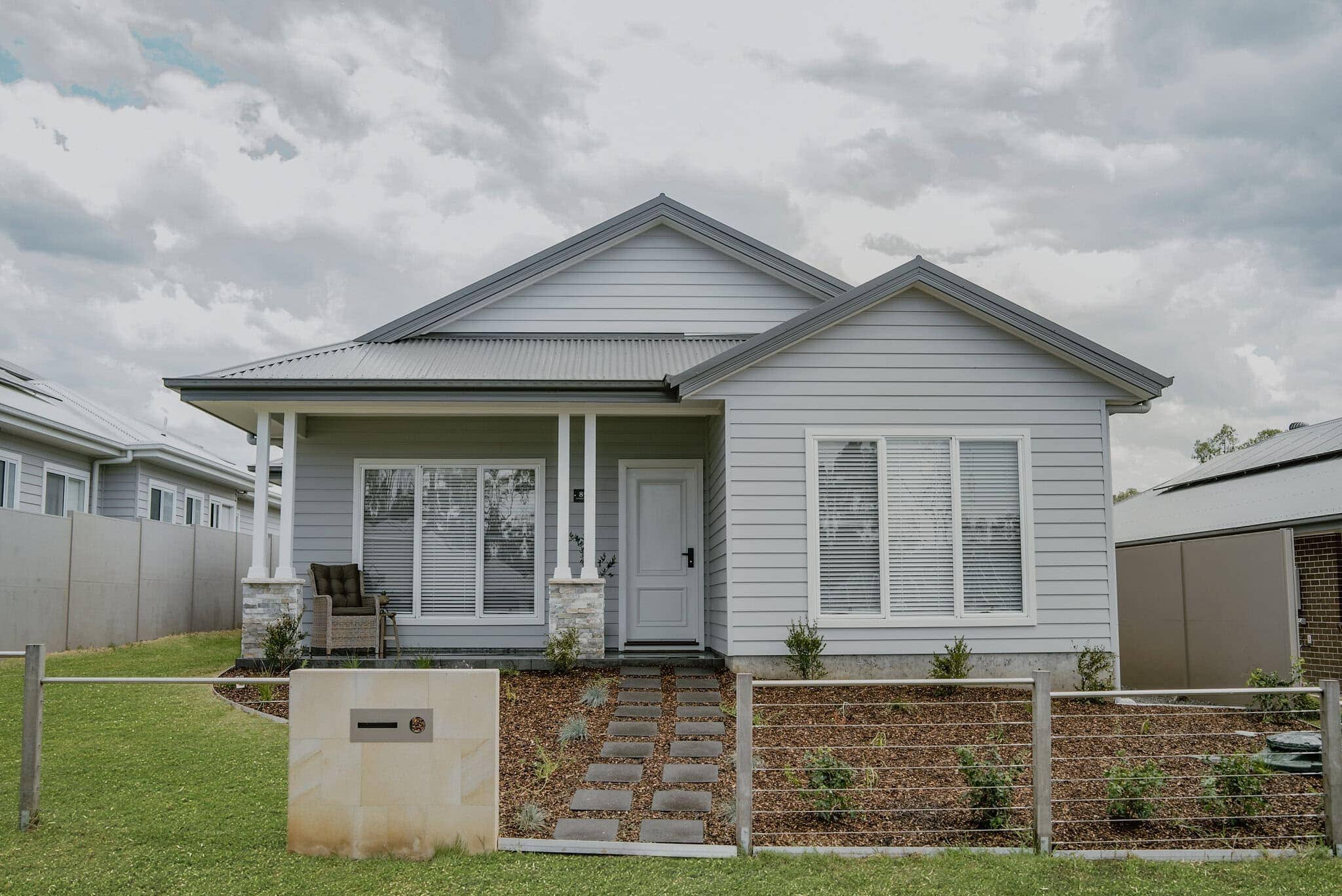 Modern white family home with landscaped front yard in smart suburb, built by Edwards Family Homes Australia.