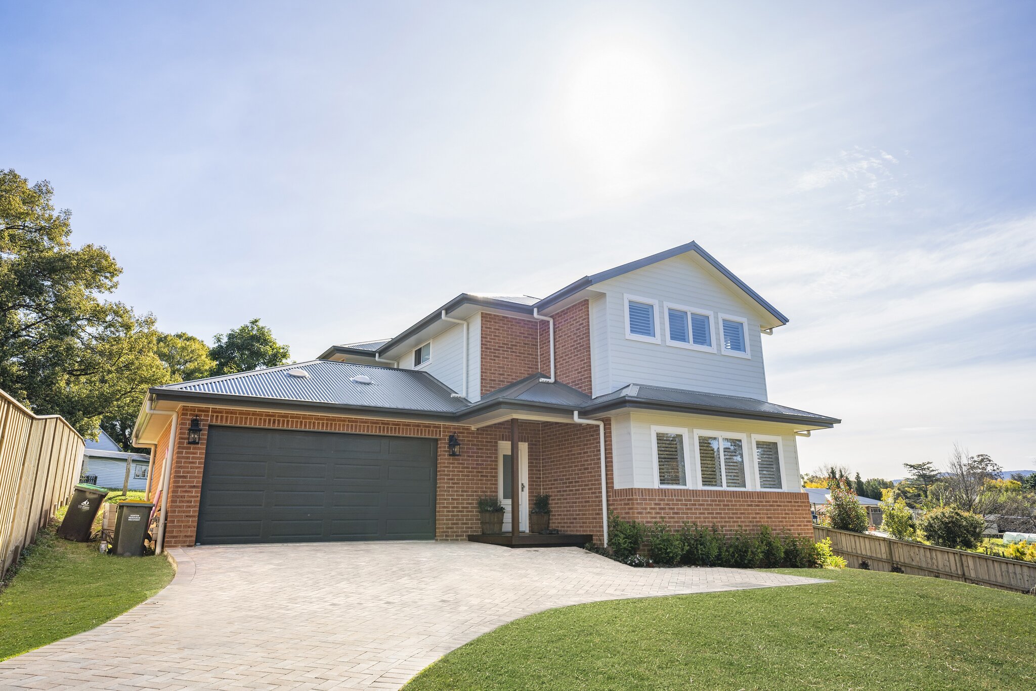 Modern two-storey family home with brick and weatherboard exterior. Spacious driveway and landscaped yard in AUD.