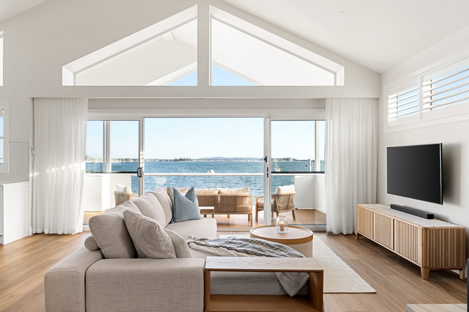 HIA Awards Finalist: Seasgair House, Paul and Bec’s Vision 1 Upstairs living room with raked ceiling and water views in a reverse-living custom home