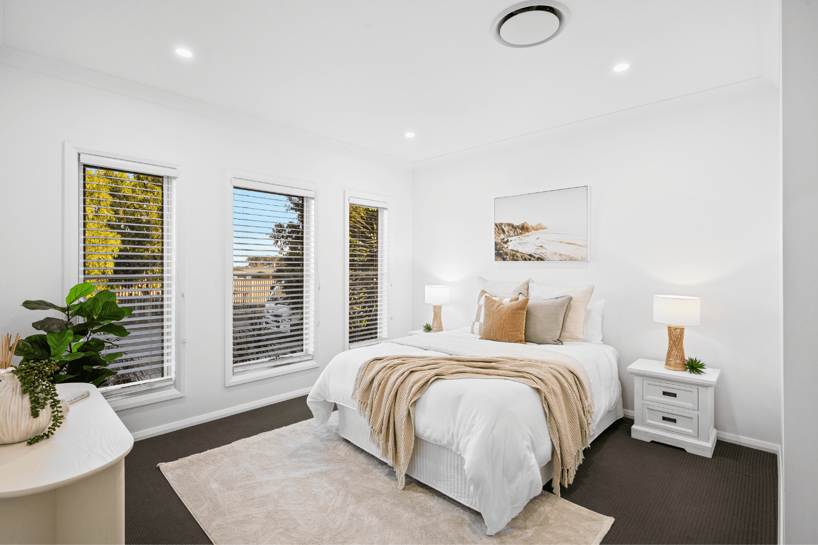 Bright modern bedroom with white walls, large windows and a cozy bed.