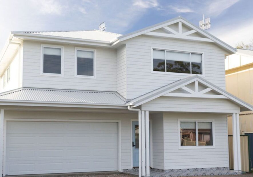 Contemporary white two-storey house with garage and gabled roof fixed price contract